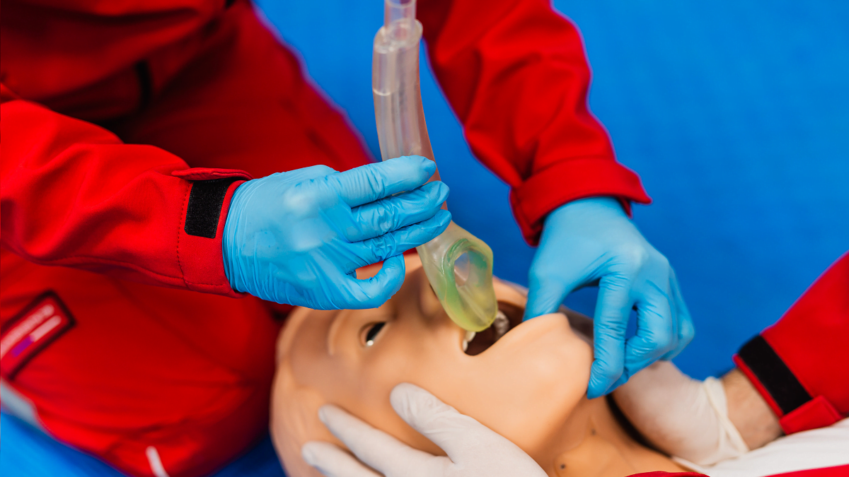 Ensihoitaja asettamasa I-gel larynxmaskia harjoittelunukelle.